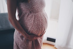pregnant woman in dress holding bump